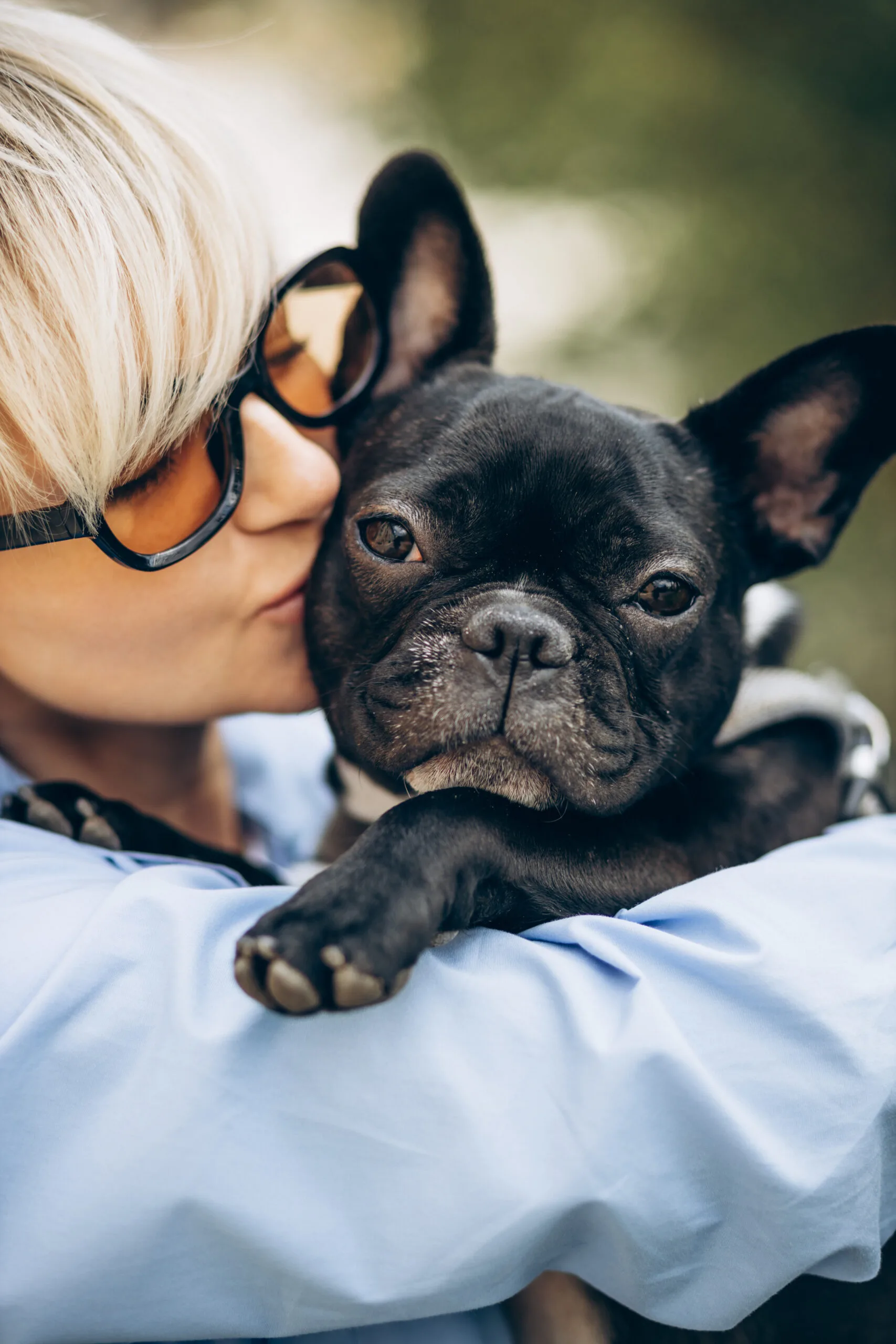Portrait d'une femme avec son bouledogue français dans un parc